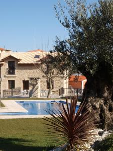 a villa with a swimming pool in front of a house at Hotel Apartamento Marouco in A Guarda