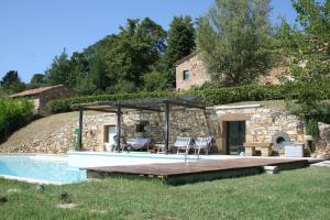 una casa de piedra con un patio con piscina en Godiolo, en Montepulciano