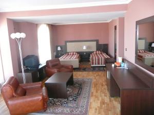 a living room with a couch chairs and a living room at Hotel Consul in Sofia