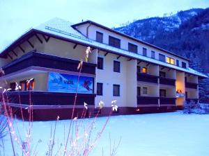a building in the snow in front of a mountain at Ski Vital Apartments in Sankt Michael im Lungau