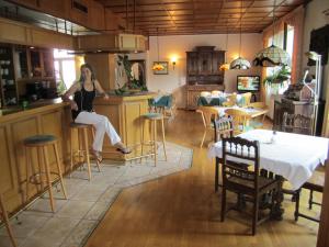 a woman sitting on a bar in a kitchen at Hotel Fährhaus in Saarbrücken