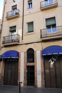 バルセロナにあるApartamentos Bejarのガレージドア2つと窓2つが付いた建物