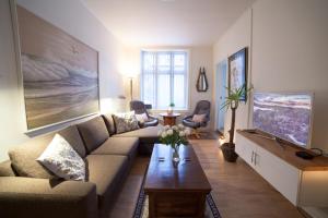 een woonkamer met een bank en een tafel bij Vika I, As Home in Oslo