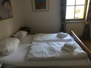 a bedroom with two beds with white sheets and towels at Residenz Allgäublick, Ihr Bett im Allgäu in Bad Hindelang