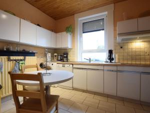 una cucina con armadi bianchi, tavolo e finestra di Boutique Holiday Home in Durbuy with Garden a Verlaine