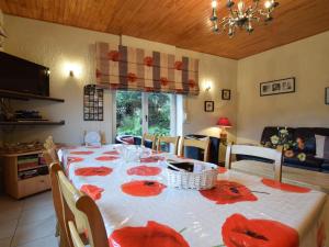 uma sala de jantar com uma mesa com flores vermelhas em Boutique Holiday Home in Durbuy with Garden em Verlaine