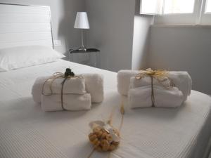 białe łóżko z ręcznikami i wypchanymi zwierzętami w obiekcie Arco' B&B w mieście Trani