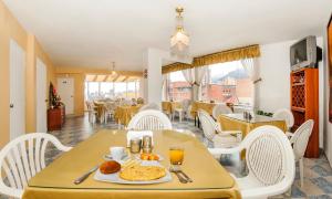 a dining room with a table with a plate of food at Hotel Bogotá Gran Marquez in Bogotá