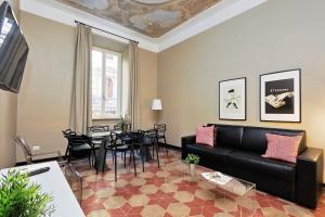 ein Wohnzimmer mit einem Sofa und einem Tisch in der Unterkunft Monti Apartments - My Extra Home in Rom