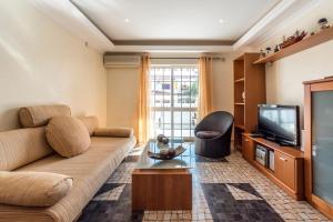 a living room with a couch and a tv at Apartamento Altura in Altura