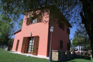 a pink building with a street light in front of it at La Bettola Tavern Rooms & Restaurant in Montopoli in Val dʼArno