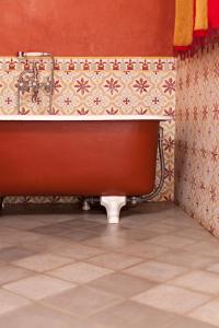 a red and white tiled bathroom with a red rug at Alcoba del Rey de Sevilla in Seville
