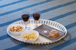 a tray with two glasses of wine and snacks on a table at Ruins B&B in Ercolano