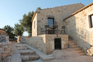 a stone building with a window and stairs in front of it at Tenuta Zannafondo in Donnafugata