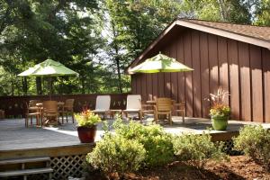 a wooden deck with chairs and tables and umbrellas at Lake Forest Resort in Eagle River
