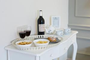 a white table with a bottle of wine and wine glasses at Ruins B&B in Ercolano