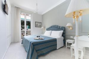 a white and blue bedroom with a bed and a sink at Ruins B&B in Ercolano