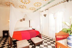 a bedroom with a red bed and a checkered floor at Alcoba del Rey de Sevilla in Seville +119 photos