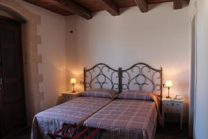 a bedroom with a bed with two night stands and two lamps at Tenuta Zannafondo in Donnafugata