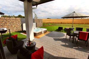 a patio with a hot tub and a table and chairs at Ferienhaus CASA OASIS in Göhren-Lebbin