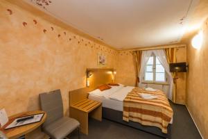 Pokój hotelowy z łóżkiem, biurkiem i krzesłem w obiekcie Pension Galko w Czeskim Krumlovie