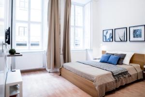 ブダペストにあるHigh Trees Apartmentのベッドルーム1室(青い枕と窓付きのベッド1台付)