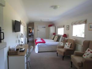 ein Schlafzimmer mit einem Bett, einem Sofa und einem Tisch in der Unterkunft Home Farm Boreham in Warminster