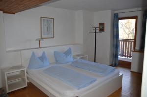 a bedroom with a white bed with blue pillows at Gasthof Johannesmesner in Sankt Paul im Lavanttal