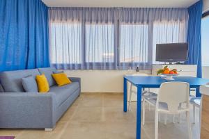 a living room with a blue couch and a table at Villa Vo' Scurá in Alcamo Marina