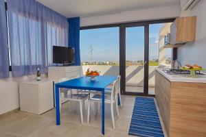 a kitchen with a blue table and a kitchen with a window at Villa Vo' Scurá in Alcamo Marina