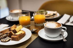 un tavolo con un piatto di cibo e una tazza di caffè di The Shire Hotel a Roma