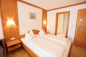 a bedroom with a white bed in a room at Akzent Hotel Alpenrose in Nesselwang