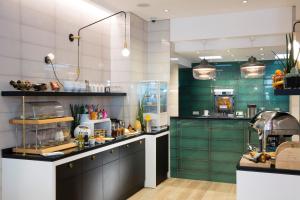 a kitchen with green and white walls and counters at Hotel Haussmann Saint Augustin in Paris