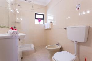 a white bathroom with a toilet and a sink at Casa Concha - Peaceful and Relaxing in Lagos