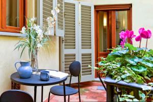 un patio con tavolo, sedie e fiori di Appartamento La Tranquilla a Firenze