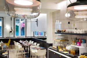 a restaurant with tables and white chairs and lights at Hotel Haussmann Saint Augustin in Paris