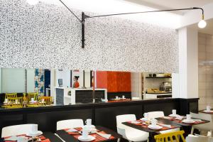 a dining room with tables and white chairs at Hotel Haussmann Saint Augustin in Paris
