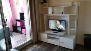 uma sala de estar com televisão numa prateleira de livros brancos em Résidence Cap Azur Appartement 217 em Villeneuve-Loubet