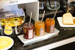 a kitchen counter with three jars of jam and bread at Hotel Haussmann Saint Augustin in Paris