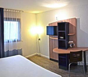 a hotel room with a desk and a bed and a room with a bed gmaxwell at Art Hotel Paris Est in Pantin