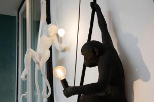 a statue of a monkey holding a light in front of a wall at Hotel Haussmann Saint Augustin in Paris