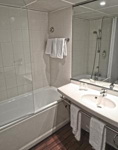 La salle de bains est pourvue d'une baignoire, d'un lavabo et d'une baignoire. dans l'établissement Art Hotel Paris Est, à Pantin