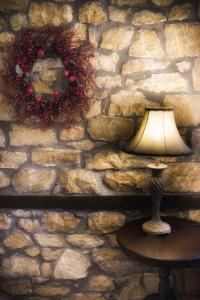 a lamp on a table in front of a stone wall at Archontiko Emmanouilidi Suites in Kato Loutraki