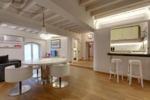 sala de estar y cocina con mesa y sillas en Capitelli Suite, en Florencia