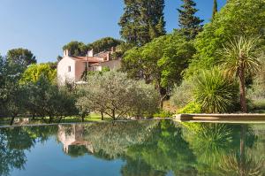 a large pool of water with a house in the background at La Royante in Aubagne