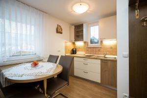a kitchen with a table and chairs and a kitchen with white cabinets at Apartments & Rooms Malej in Bohinj