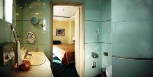 una camera da letto con un letto e un bagno con un lavandino di Nafsika Palace Delphi-Itea a Itea