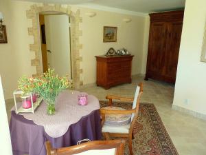 a dining room with a table with a vase of flowers on it at La Royante in Aubagne