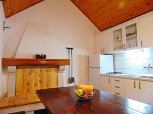 a kitchen with a wooden table with a bowl of fruit on it at House Sv. Lovre in Postira