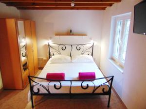 a bedroom with a bed with two red pillows on it at House Sv. Lovre in Postira +25 photos